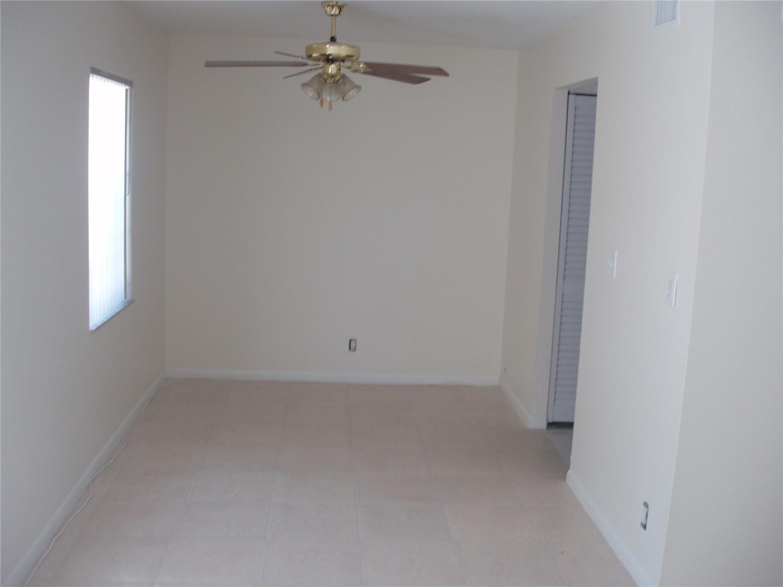 An empty room with beige tile flooring, a ceiling fan, and a single window — 8028 SW 17th Place, Davie FL 33324, DAVIE, FL