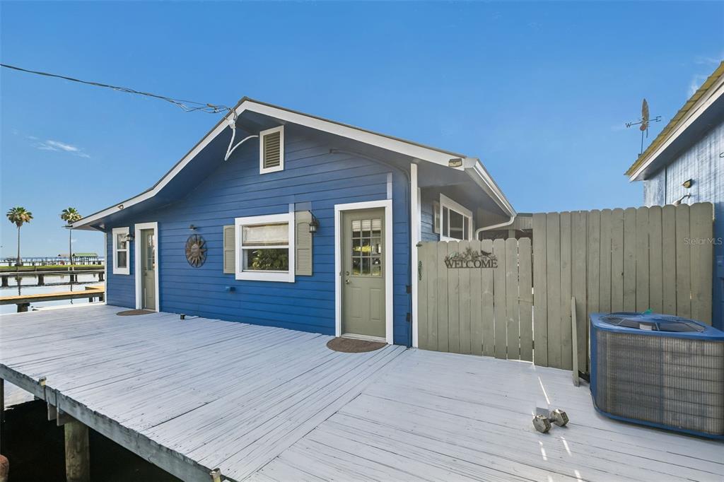 A blue house with a large white deck sits on stilts over the water — 21 S LAKE STREET, CRESCENT CITY, FL
