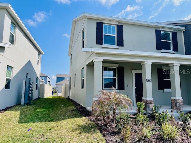 A two-story house with light green siding and a covered front porch — 2639 CANDIED APPLE ALLEY, KISSIMMEE, FL