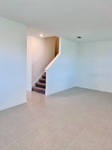 An interior view shows a tiled room with a staircase leading to an upper level — 2639 CANDIED APPLE ALLEY, KISSIMMEE, FL