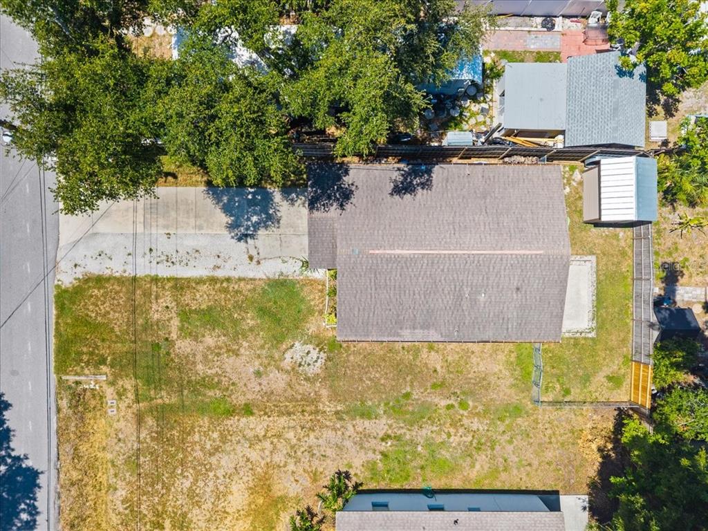 An aerial view shows a house with a gray roof, a driveway, and a yard — 4050 ROCKEFELLER AVENUE, SARASOTA, FL