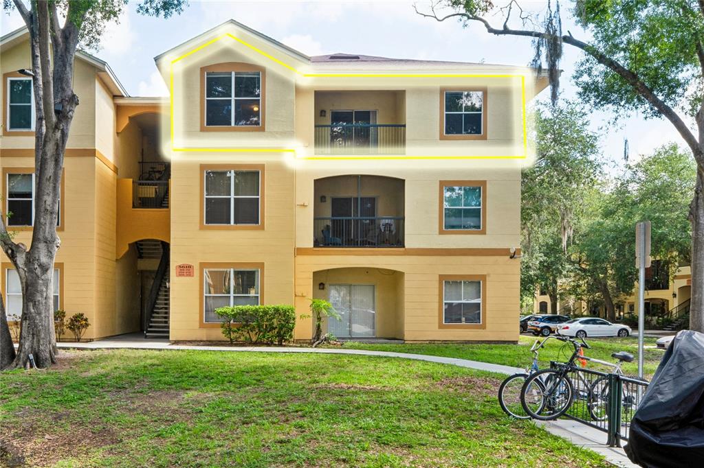 The exterior of a three-story apartment building with a highlighted top-floor unit — 5618 PINNACLE HEIGHTS CIRCLE UNIT 312, TAMPA, FL