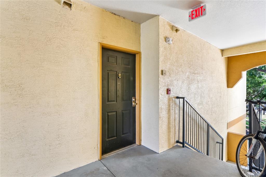 A dark entry door is located on a concrete landing next to an outdoor staircase — 5618 PINNACLE HEIGHTS CIRCLE UNIT 312, TAMPA, FL