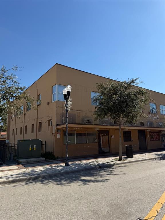 A three-story tan commercial building with a flat roof and a street-level awning — 221 S PARRAMORE AVENUE UNIT 7A, ORLANDO, FL