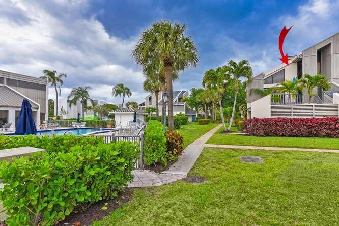 An exterior view of a multi-story residential building with a pool and palm trees — 1605 S Us Highway 1 # 9h, Jupiter FL 33477, JUPITER, FL