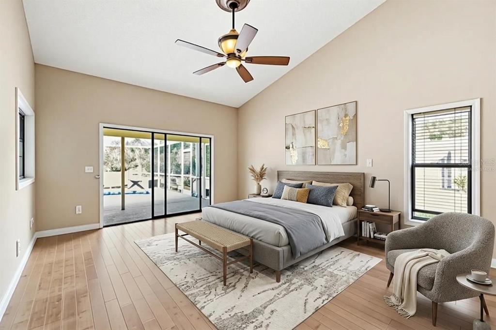 A bedroom features a vaulted ceiling, wood flooring, a sliding glass door, and a ceiling fan — 8432 PALM LAKES COURT, SARASOTA, FL
