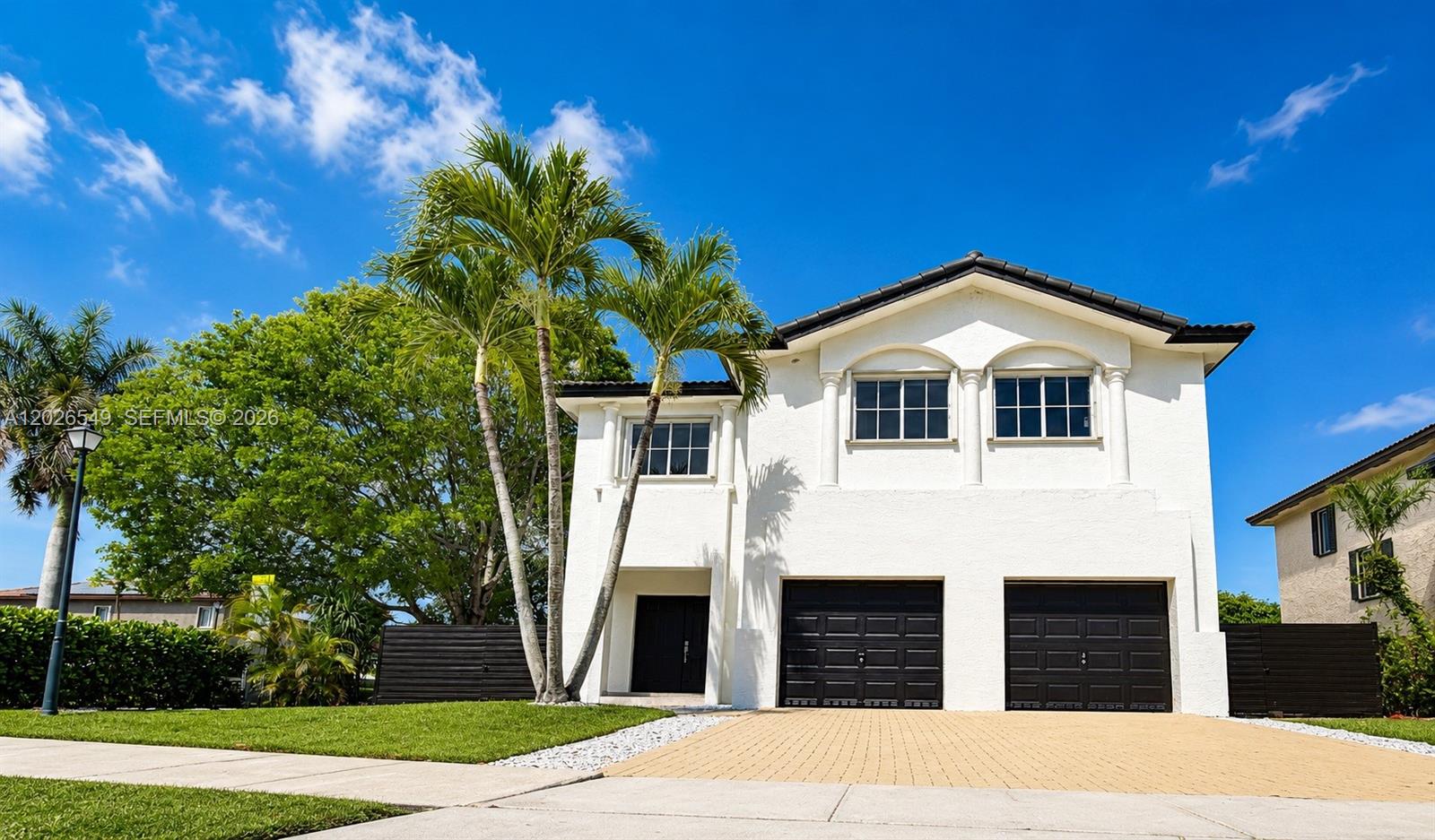 A two-story white house features a double garage, palm trees, and a paved driveway — 14407 SW 158th Path, Miami FL 33196, MIAMI, FL