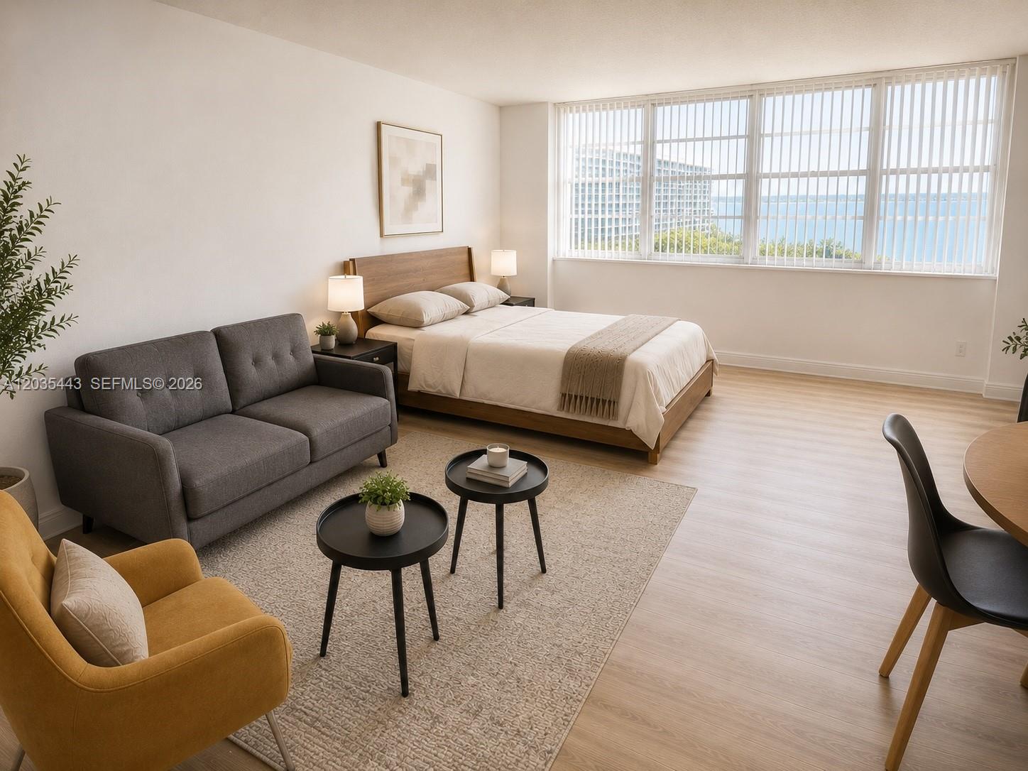 This studio apartment features a bed, sofa, seating area, and large windows with water views — 801 Brickell Bay Dr # 1469, Miami FL 33131, MIAMI, FL