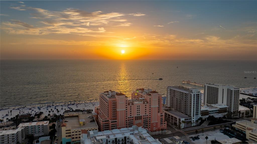 An aerial view of a large, pink multi-story hotel building situated near a sandy beach — 301 S GULFVIEW BOULEVARD UNIT 301, CLEARWATER BEACH, FL