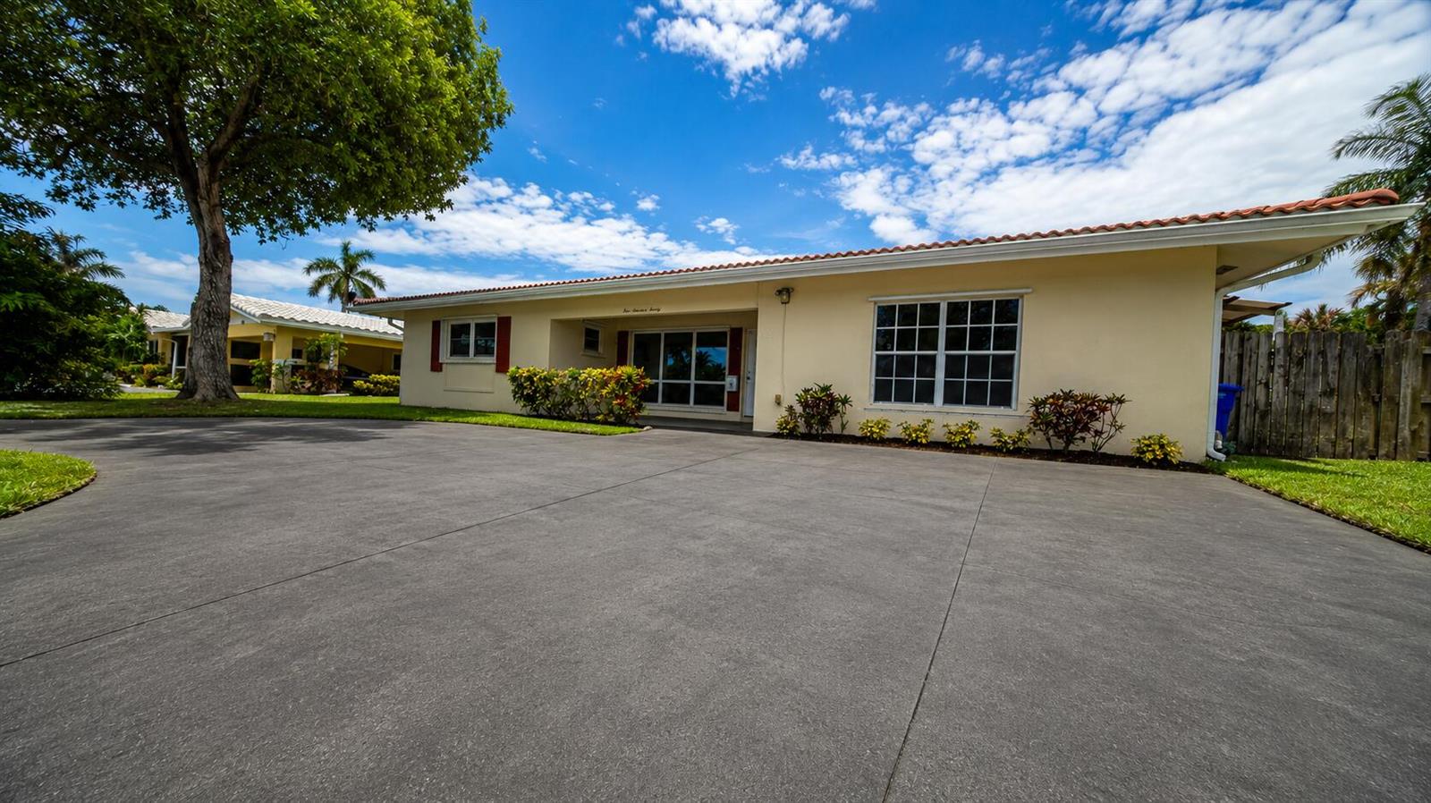 A single-story house with a large concrete driveway, a tiled roof, and landscaped front yard — 420 SE 4th Court, Pompano Beach FL 33060, POMPANO BEACH, FL