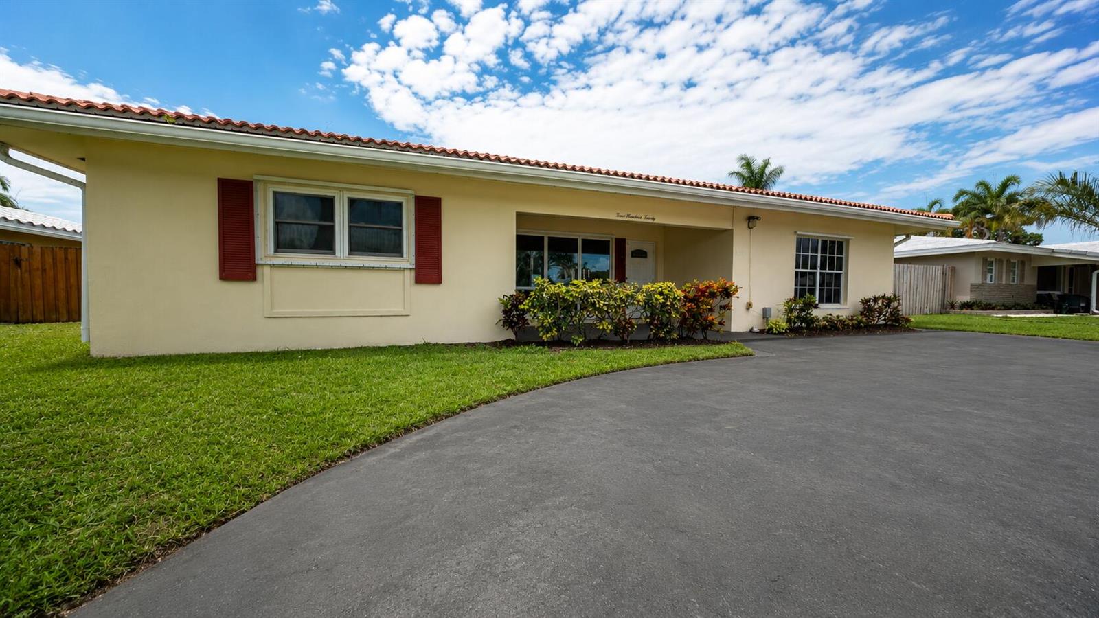 A single-story house with a yellow exterior, red shutters, and a paved driveway — 420 SE 4th Court, Pompano Beach FL 33060, POMPANO BEACH, FL