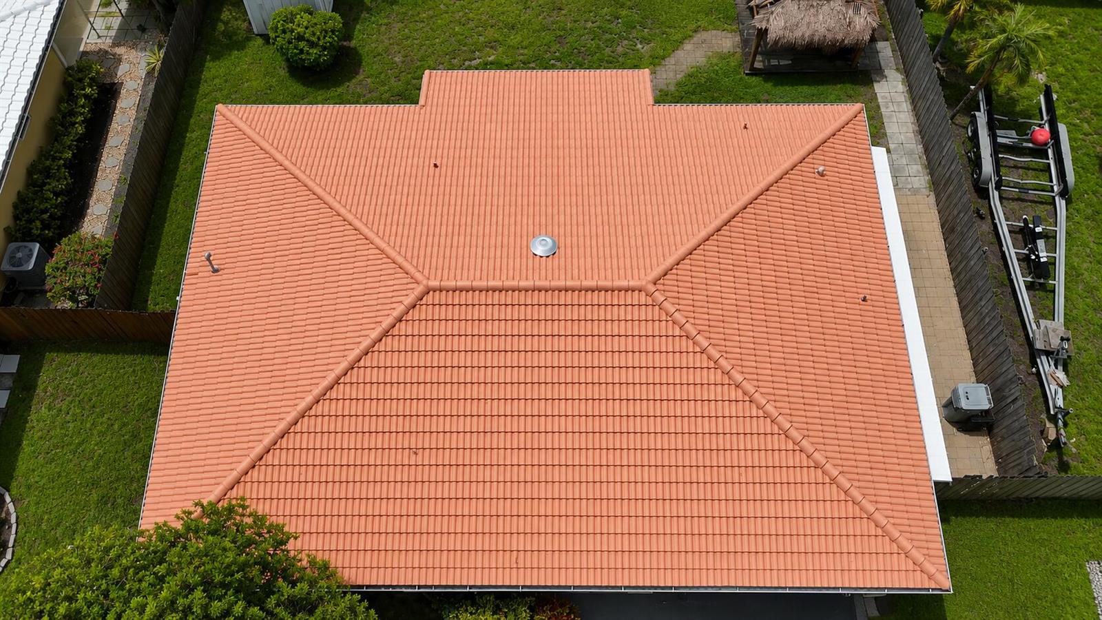 An aerial view shows a terracotta-tiled hip roof on a residential home with a central vent — 420 SE 4th Court, Pompano Beach FL 33060, POMPANO BEACH, FL