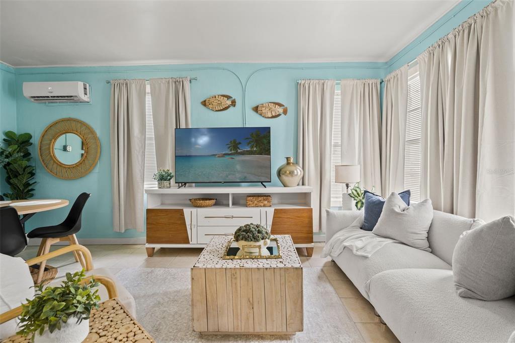 A living room features light blue walls, a white media console, and a white sofa — 1303 S BERMUDA BOULEVARD, TAMPA, FL