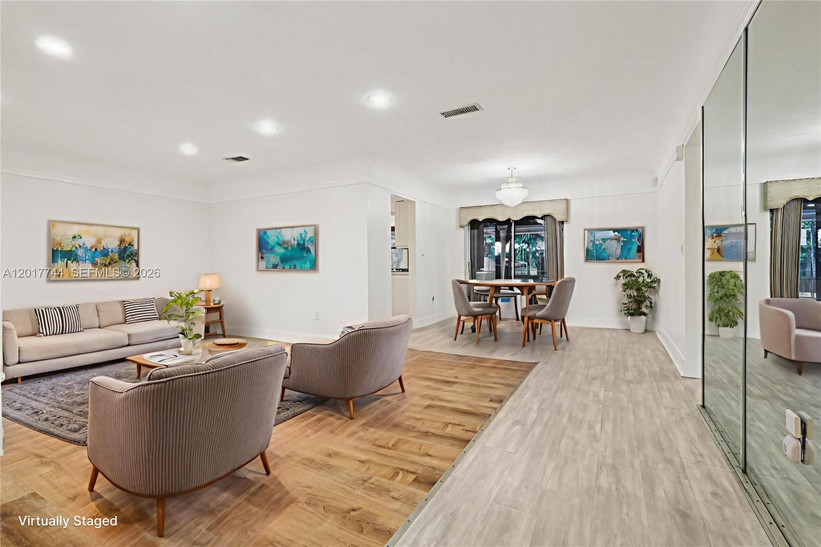 A living and dining area features light wood-look flooring, white walls, and modern furniture — 3842 Jasmine Avenue, Miramar FL 33023, MIRAMAR, FL