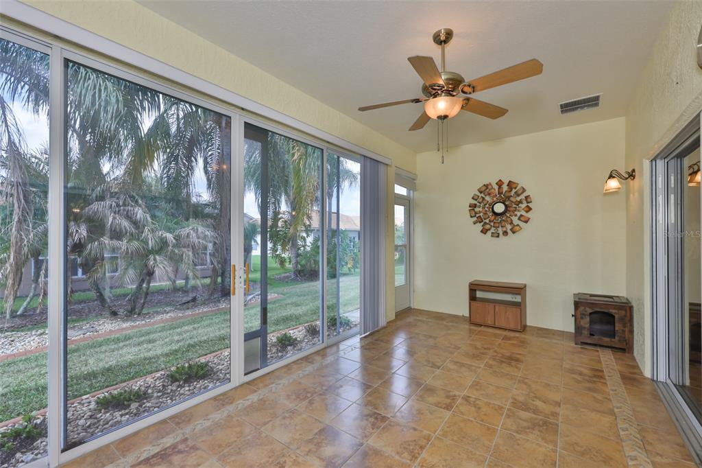 A sunroom with tile flooring, a ceiling fan, and sliding glass doors overlooking a yard — 4465 STRATHMORE DRIVE, LAKE WALES, FL
