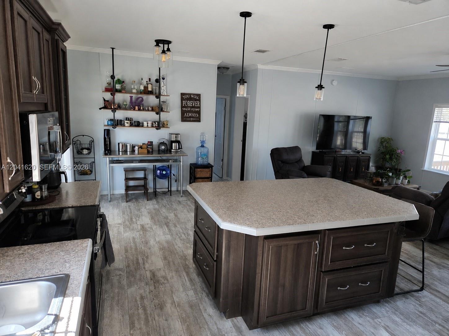 A kitchen features a large central island, dark wood cabinetry, and an open living area — OTHER CITY - IN THE STATE OF FLORIDA, FL