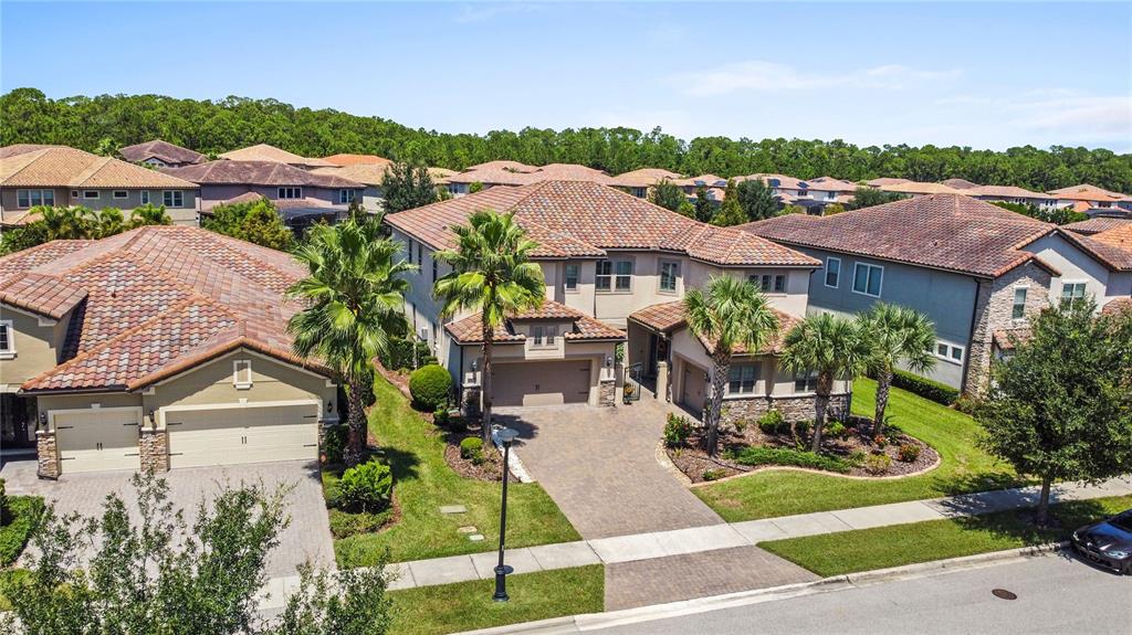 An aerial view shows two suburban houses with tiled roofs, driveways, and palm trees — 10938 SAVONA WAY, ORLANDO, FL
