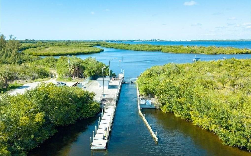 An aerial view shows a boat dock and a small utility structure surrounded by dense vegetation — 10160 AMY TERRACE, PORT CHARLOTTE, FL