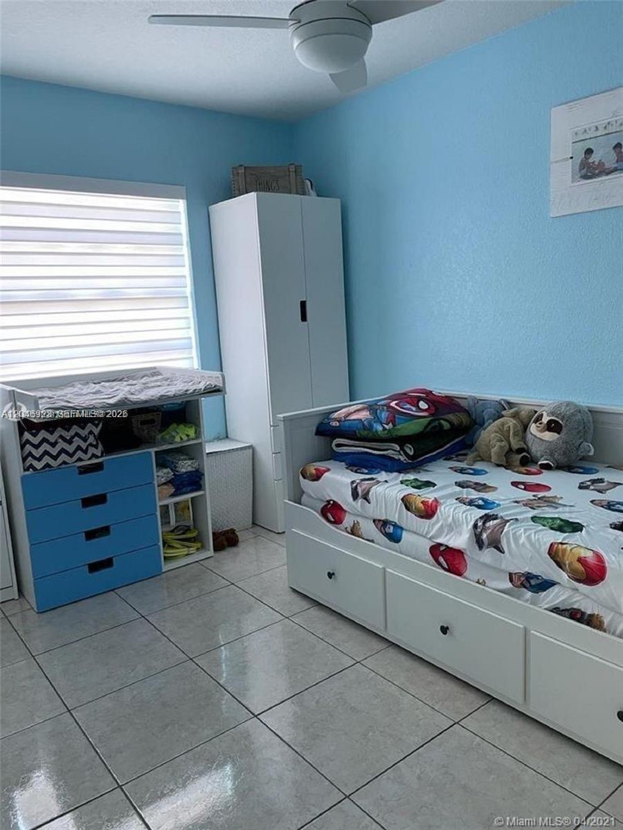 A bedroom features light blue walls, a white daybed, a matching dresser, and tiled flooring — 12860 SW 43rd Dr # B, Miami FL 33175, MIAMI, FL