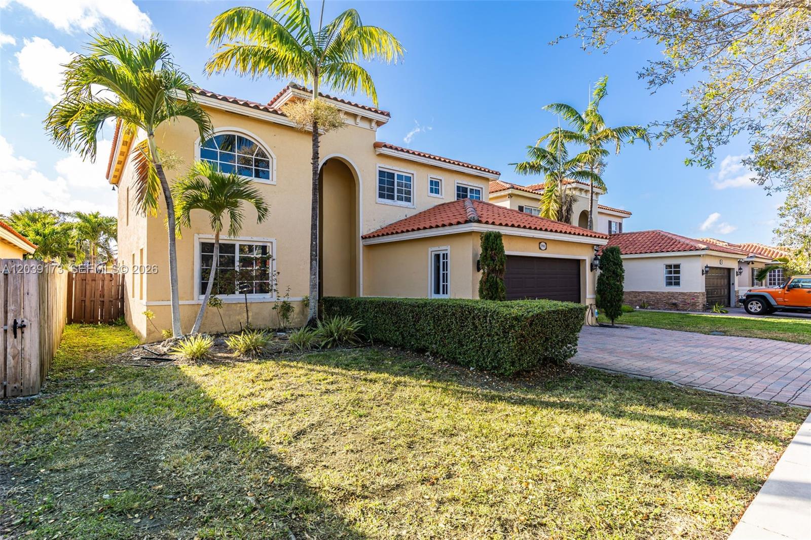 A two-story stucco house with a tile roof, palm trees, and a paved driveway — 1760 NE 36th Ave, Homestead FL 33033, HOMESTEAD, FL
