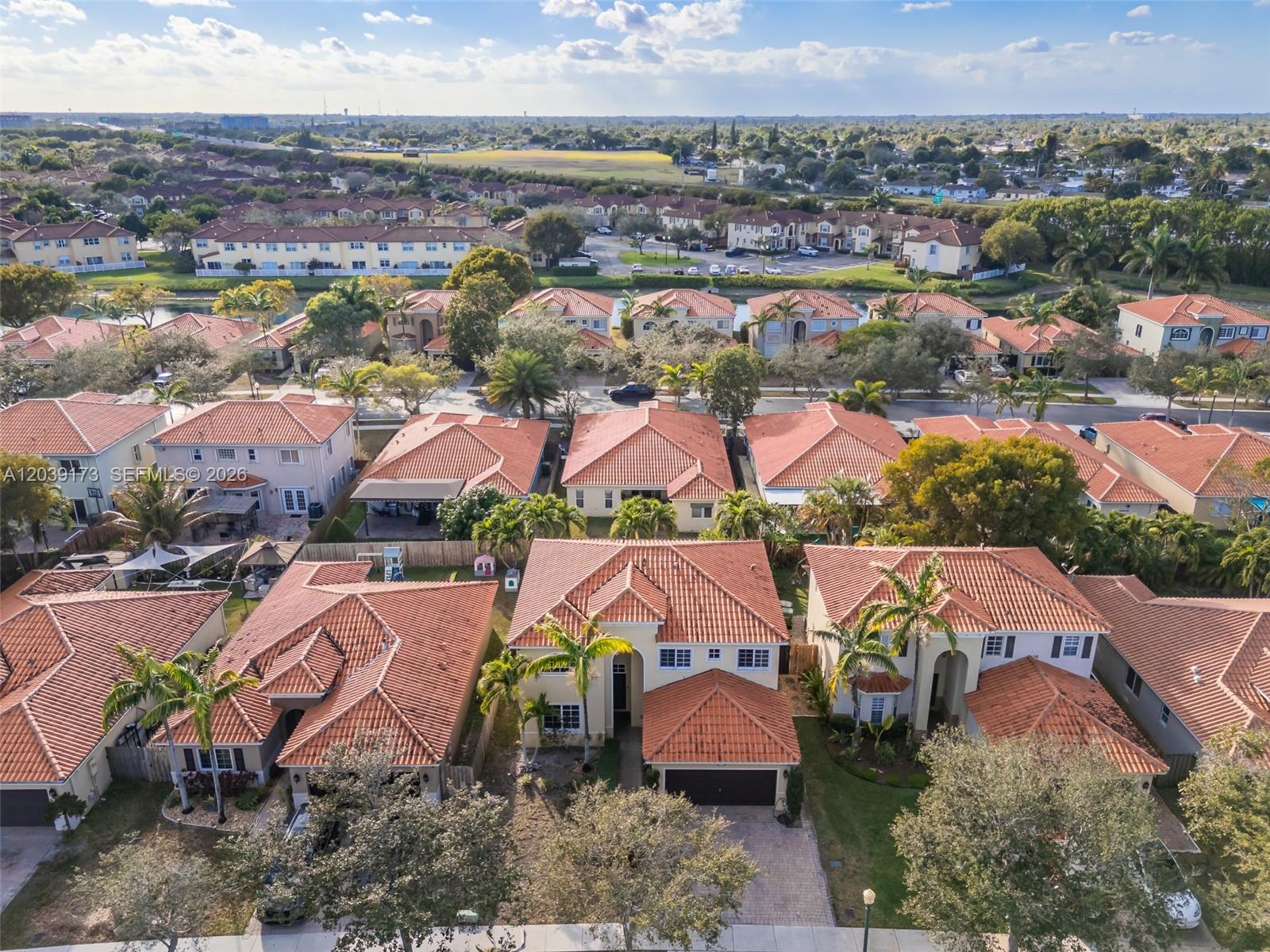 An aerial view shows a suburban neighborhood with many houses featuring terracotta-tiled roofs — 1760 NE 36th Ave, Homestead FL 33033, HOMESTEAD, FL
