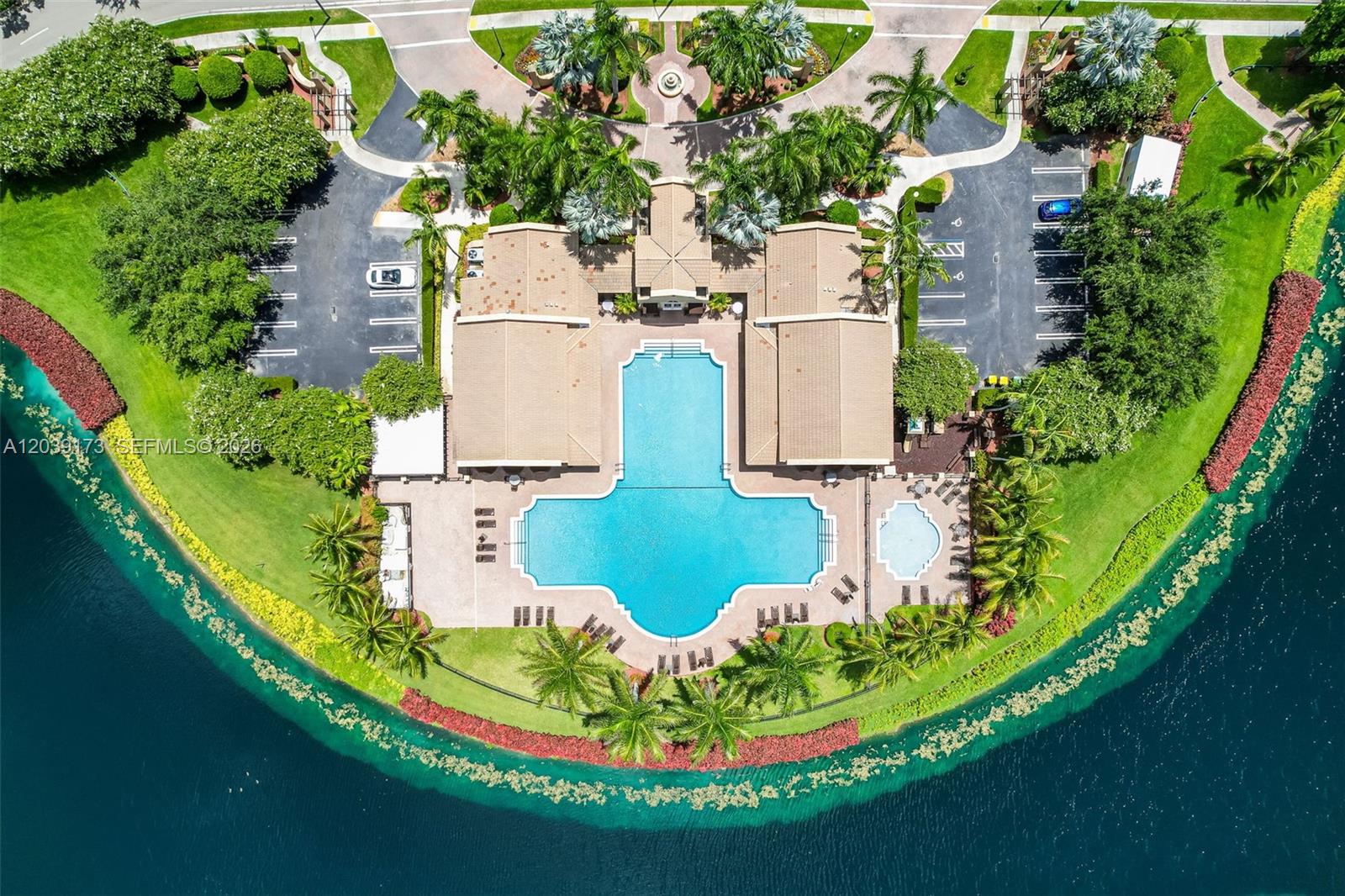 An aerial view shows a community clubhouse with a large swimming pool and parking lots — 1760 NE 36th Ave, Homestead FL 33033, HOMESTEAD, FL