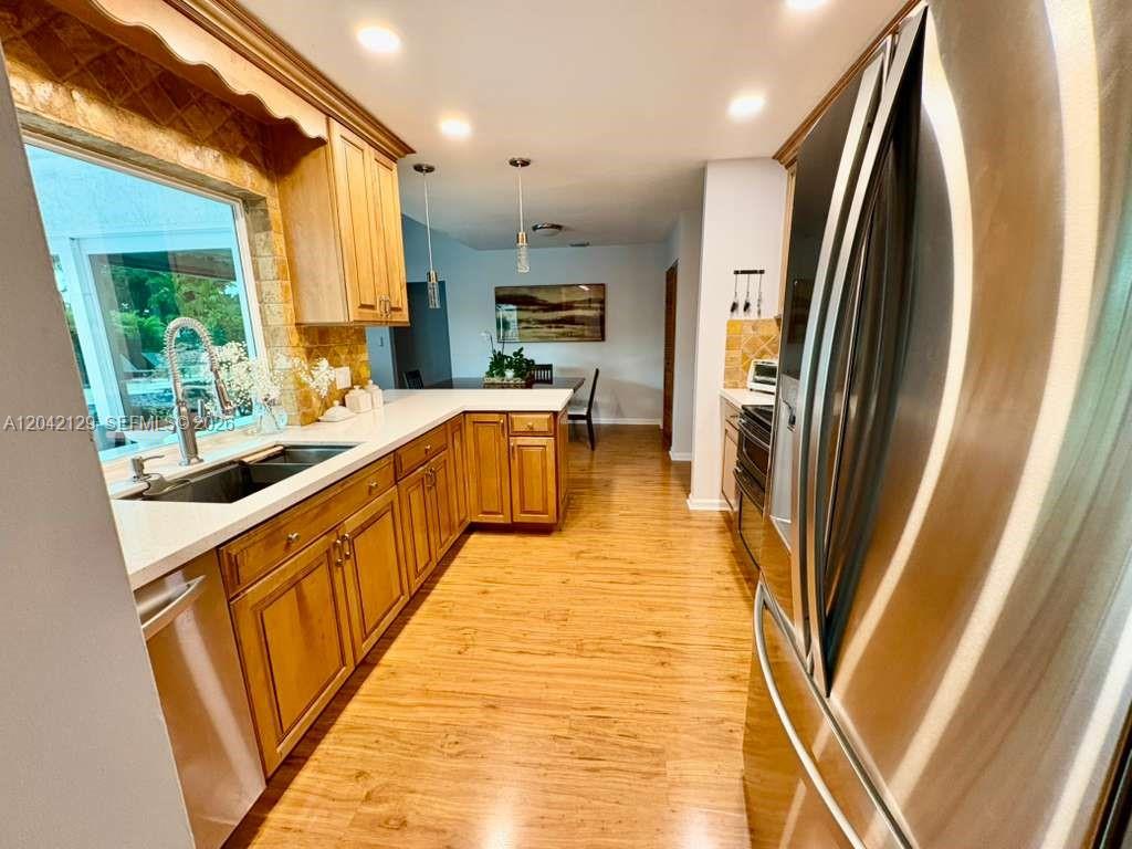 A kitchen with light wood cabinets, stainless steel appliances, and wood-look flooring — 1903 NW 79th Ave, Margate FL 33063, MARGATE, FL