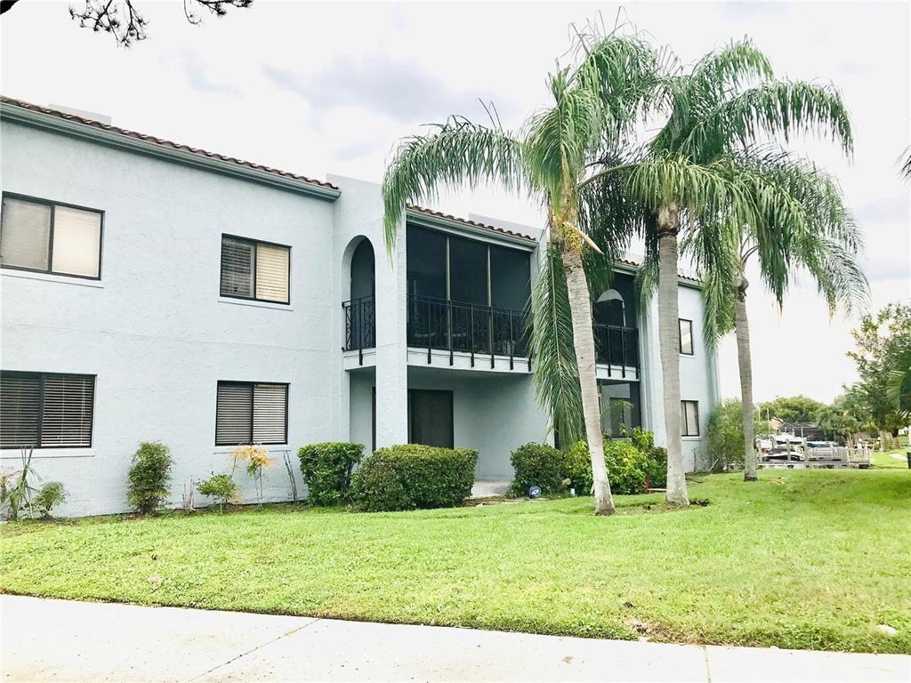 A two-story apartment building with light blue stucco walls and screened-in balconies — 6330 GRAND BAHAMA CIRCLE UNIT C, TAMPA, FL