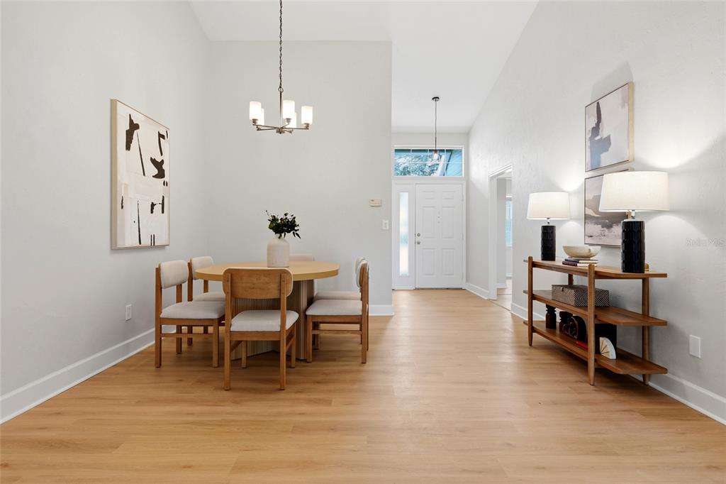 A dining area features a round wooden table, four chairs, and a console table — 10521 NW 36TH PLACE, GAINESVILLE, FL
