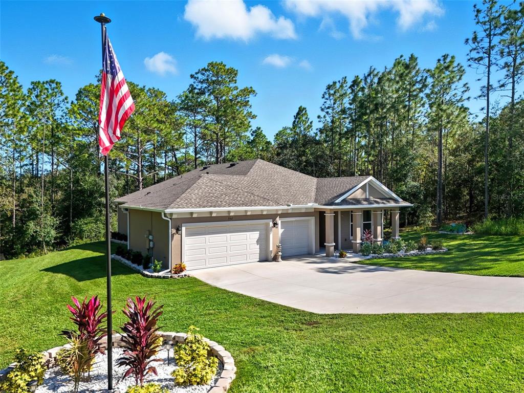 A single-story house with a two-car garage and a flag pole in the front yard — 5361 N PEPPERMINT DRIVE, BEVERLY HILLS, FL