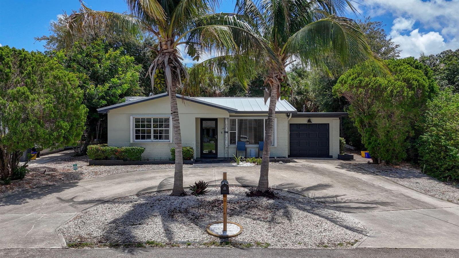 A single-story house with a metal roof, palm trees, and a circular concrete driveway — 1964 Circle Drive, North Palm Beach FL 33408, NORTH PALM BEACH, FL