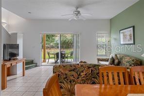 A living room with tile floors, a ceiling fan, and sliding glass doors to a patio — 1057 PARK RIDGE CIRCLE, KISSIMMEE, FL