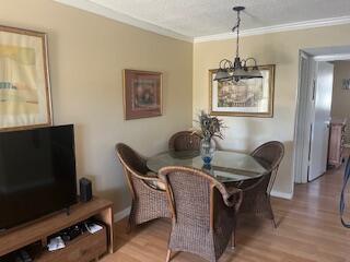 A dining area features a glass-topped table with four wicker chairs under a hanging light — 630 Snug Harbor Drive # C14, Boynton Beach FL 33435, BOYNTON BEACH, FL