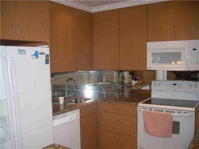 A kitchen features wood cabinets, granite countertops, a mirrored backsplash, and white appliances — 630 Snug Harbor Drive # C14, Boynton Beach FL 33435, BOYNTON BEACH, FL