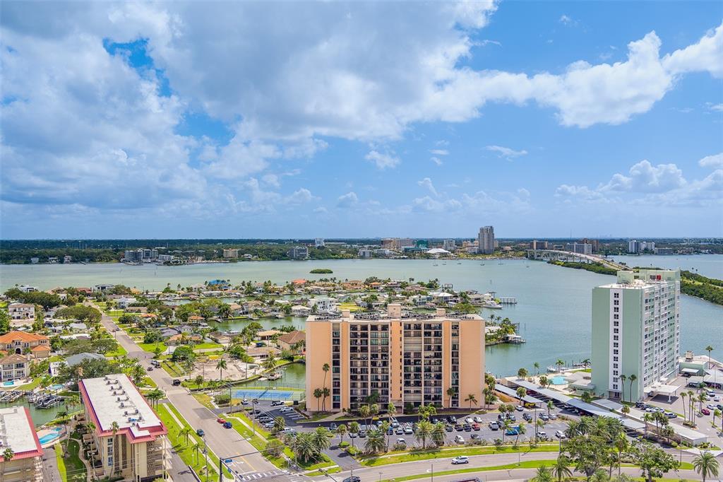 An aerial view of a waterfront neighborhood featuring high-rise apartment buildings and a bridge — 51 ISLAND WAY UNIT 101, CLEARWATER BEACH, FL
