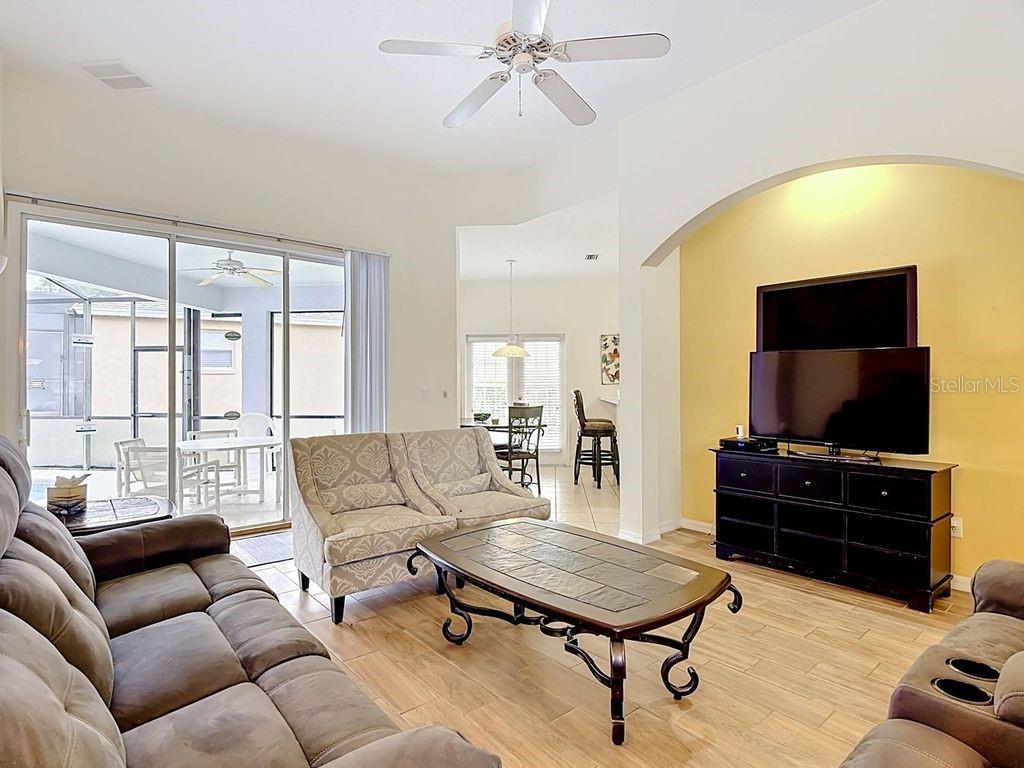 A living room with tile floors, a ceiling fan, and a view of a patio — 644 MONTARA DR, DAVENPORT, FL
