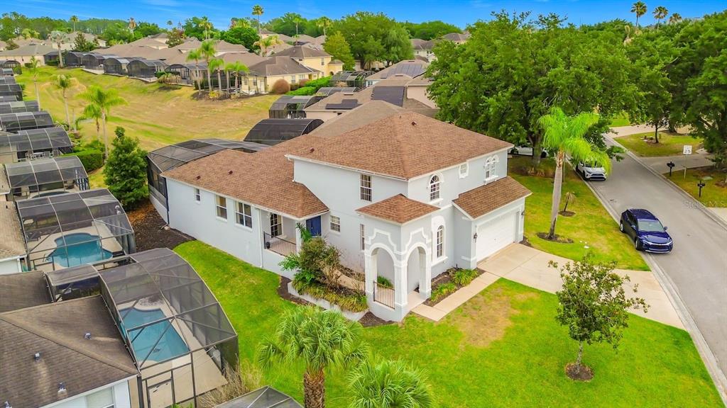An aerial view of a two-story suburban house with a pool enclosure and attached garage — 644 MONTARA DR, DAVENPORT, FL