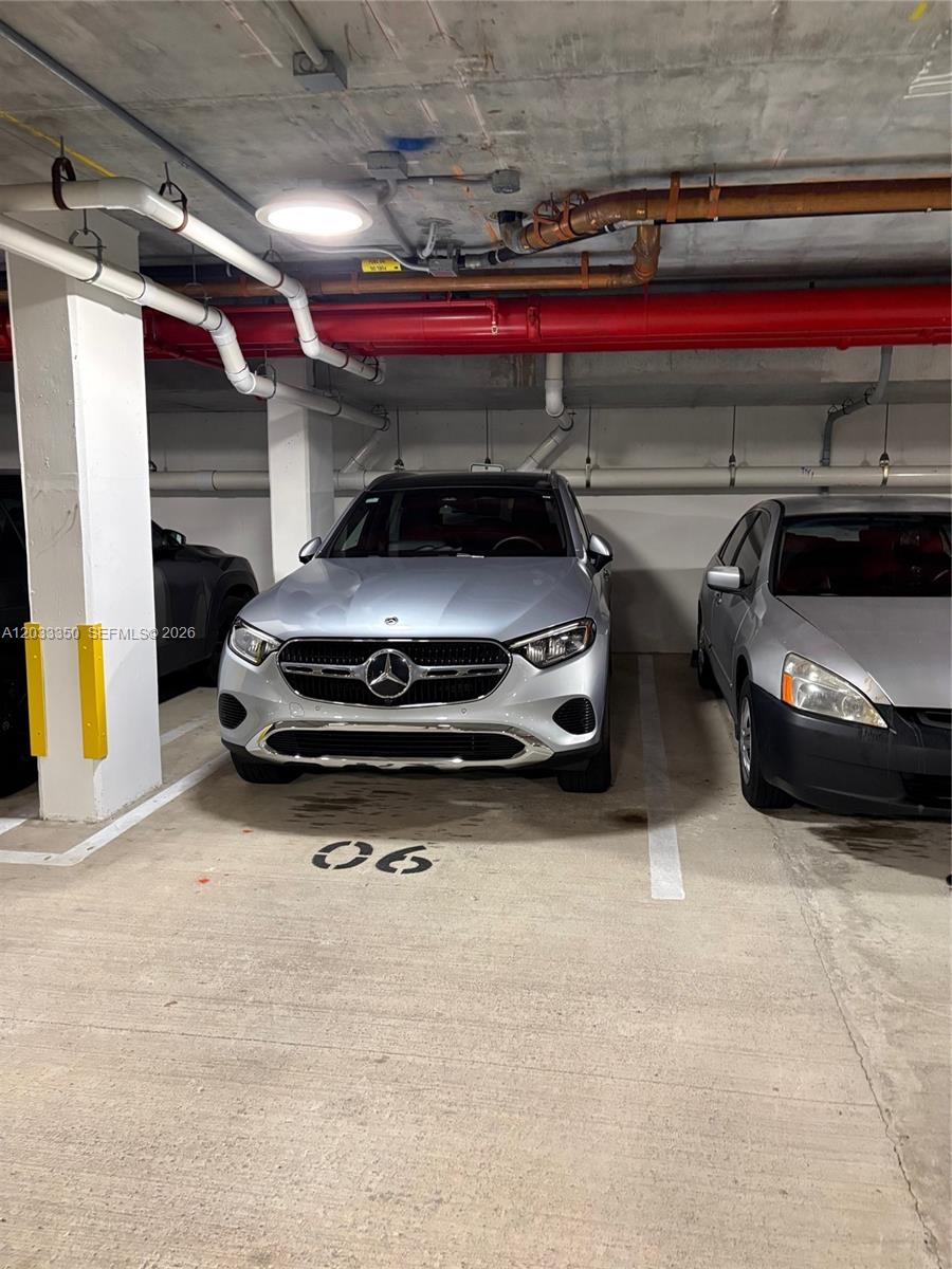 A silver Mercedes-Benz is parked in a numbered spot within a concrete parking garage — MIAMI BEACH, FL