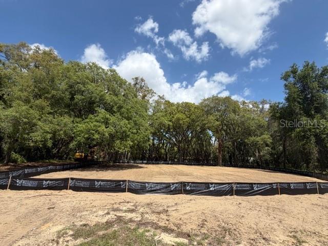 A cleared, sandy residential lot is enclosed by black silt fencing in front of trees — 17144 PHIL C PETERS ROAD, WINTER GARDEN, FL
