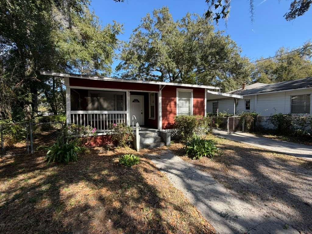 A red house with a screened-in front porch and a concrete walkway — 3404 E 33RD AVENUE, TAMPA, FL