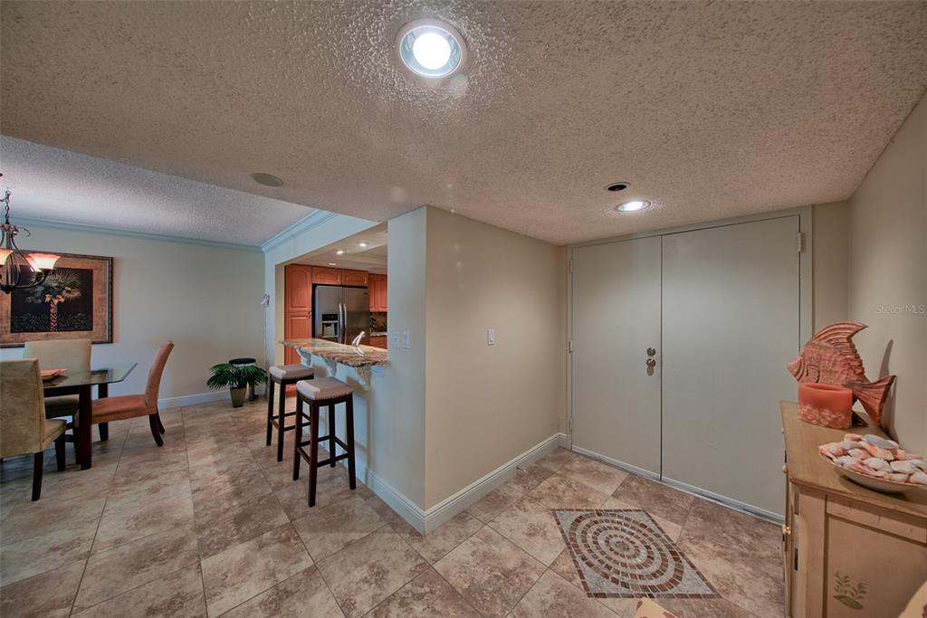 A dining area with a breakfast bar, tile floors, and double closet doors — 1480 GULF BOULEVARD UNIT 512, CLEARWATER, FL