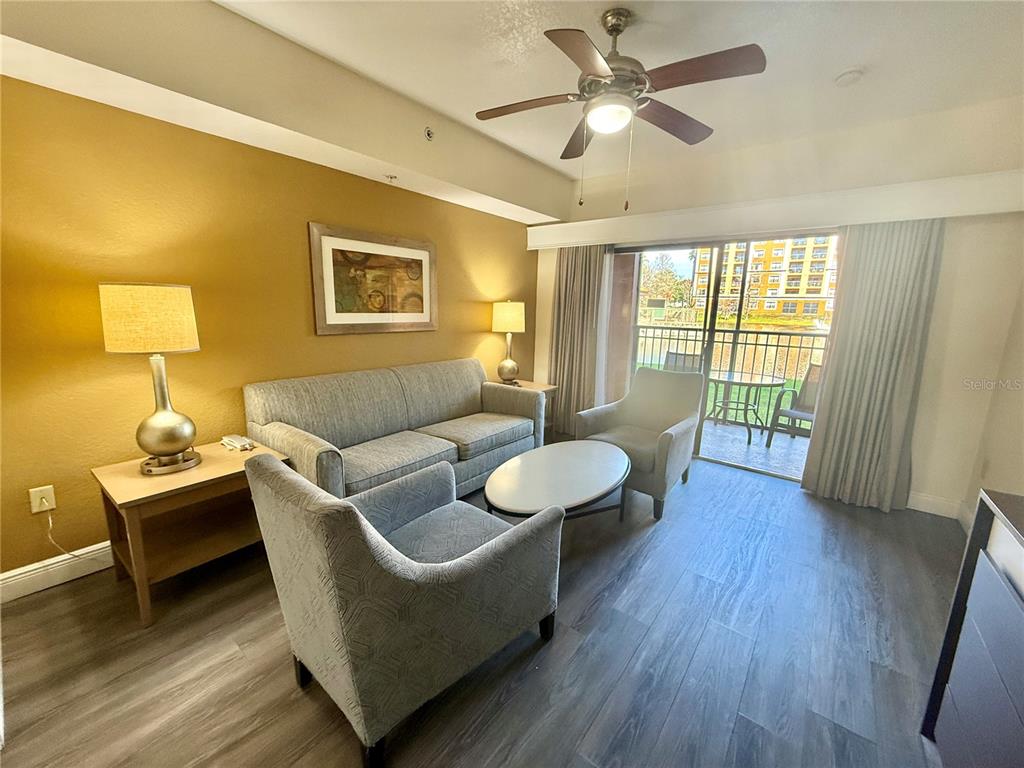 A living room features a sofa, two armchairs, a coffee table, and a sliding glass door — 12539 FLORIDAYS RESORT DRIVE UNIT 107D, ORLANDO, FL