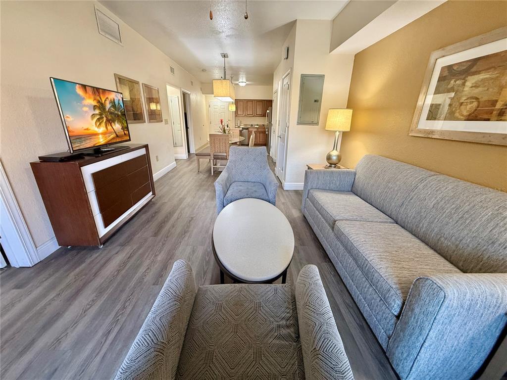 A living room features a grey sofa, two armchairs, a coffee table, and a television — 12539 FLORIDAYS RESORT DRIVE UNIT 107D, ORLANDO, FL