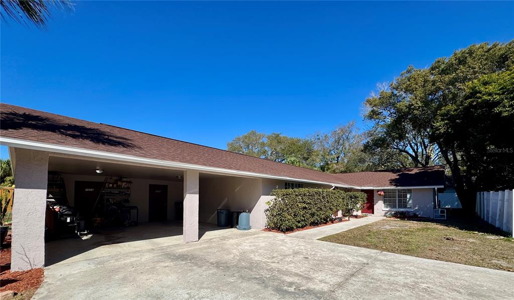 A single-story house features a large carport, a concrete driveway, and a front entrance — 7116-7118 GREEN STREET, NEW PORT RICHEY, FL