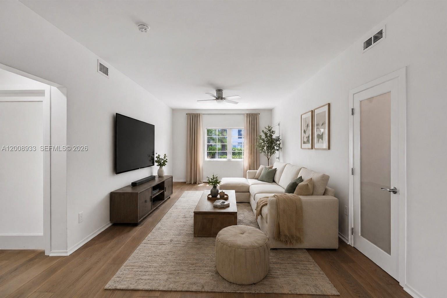 A living room features a sectional sofa, television, wood media console, and light-colored flooring — 1600 Michigan Ave # 2, Miami Beach FL 33139, MIAMI BEACH, FL