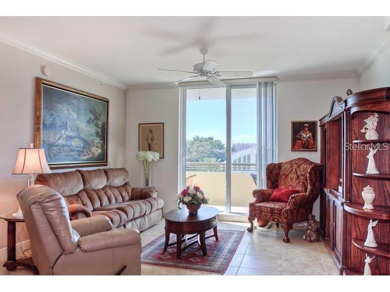 A living room features a brown sofa, a patterned armchair, and a wooden coffee table — 800 N. TAMIAMI TRAIL UNIT 303, SARASOTA, FL