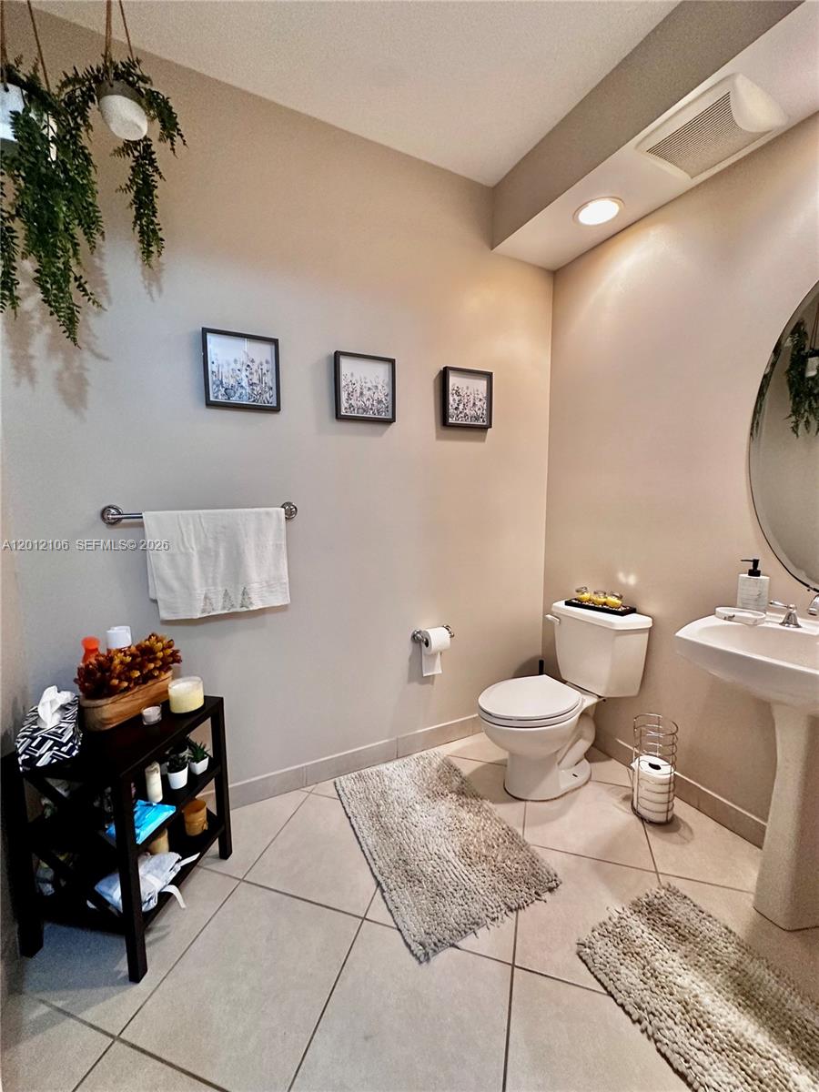 A bathroom features a pedestal sink, a toilet, a towel rack, and a small shelf — 2900 NW 125th Ave # 105, Sunrise FL 33323, SUNRISE, FL
