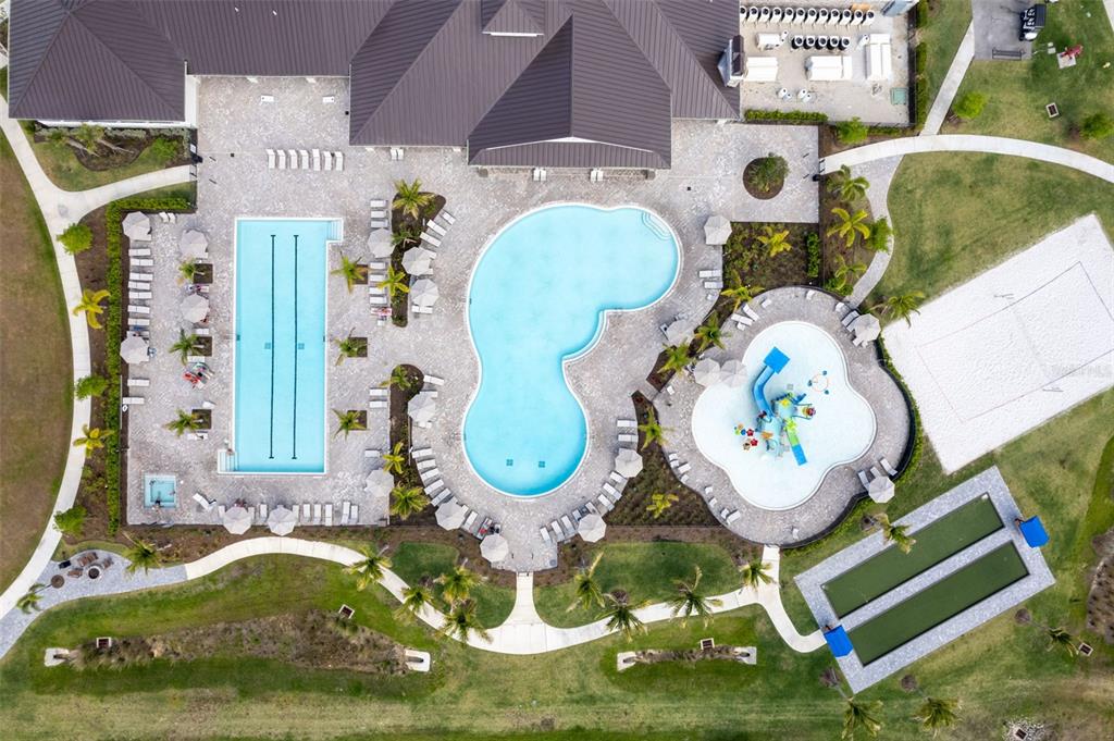An aerial view shows a community pool complex with a lap pool, splash pad, and court — 14275 PINE LODGE LANE, FORT MYERS, FL