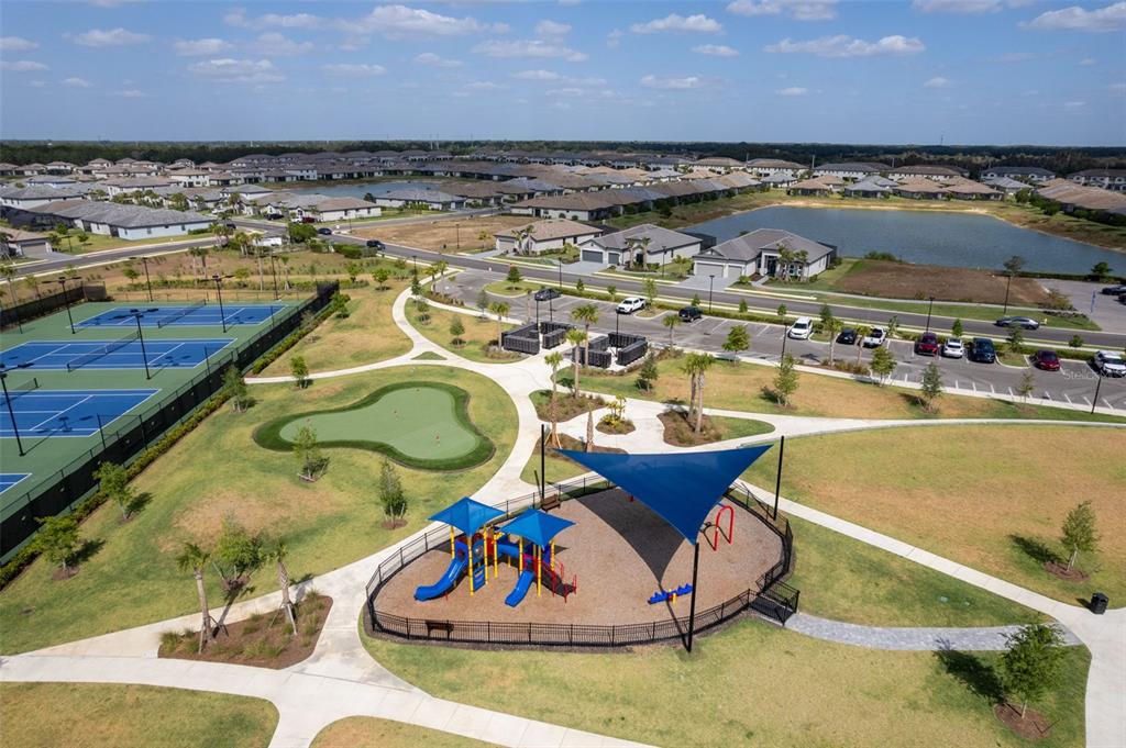 An aerial view of a community park featuring a playground, putting green, and tennis courts — 14275 PINE LODGE LANE, FORT MYERS, FL