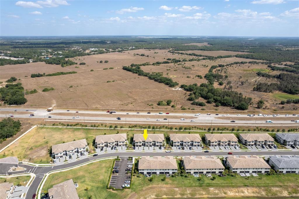 An aerial view shows a row of townhomes with a yellow arrow pointing to one unit — 14275 PINE LODGE LANE, FORT MYERS, FL